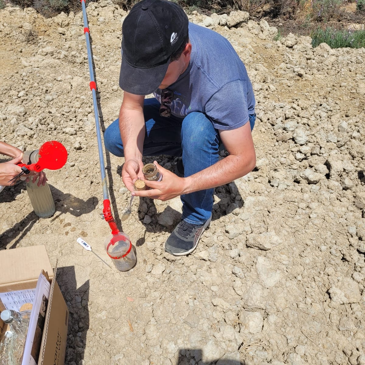 A CCMAR researcher logging a soil core from the salt-pan floor into a labelled jar.