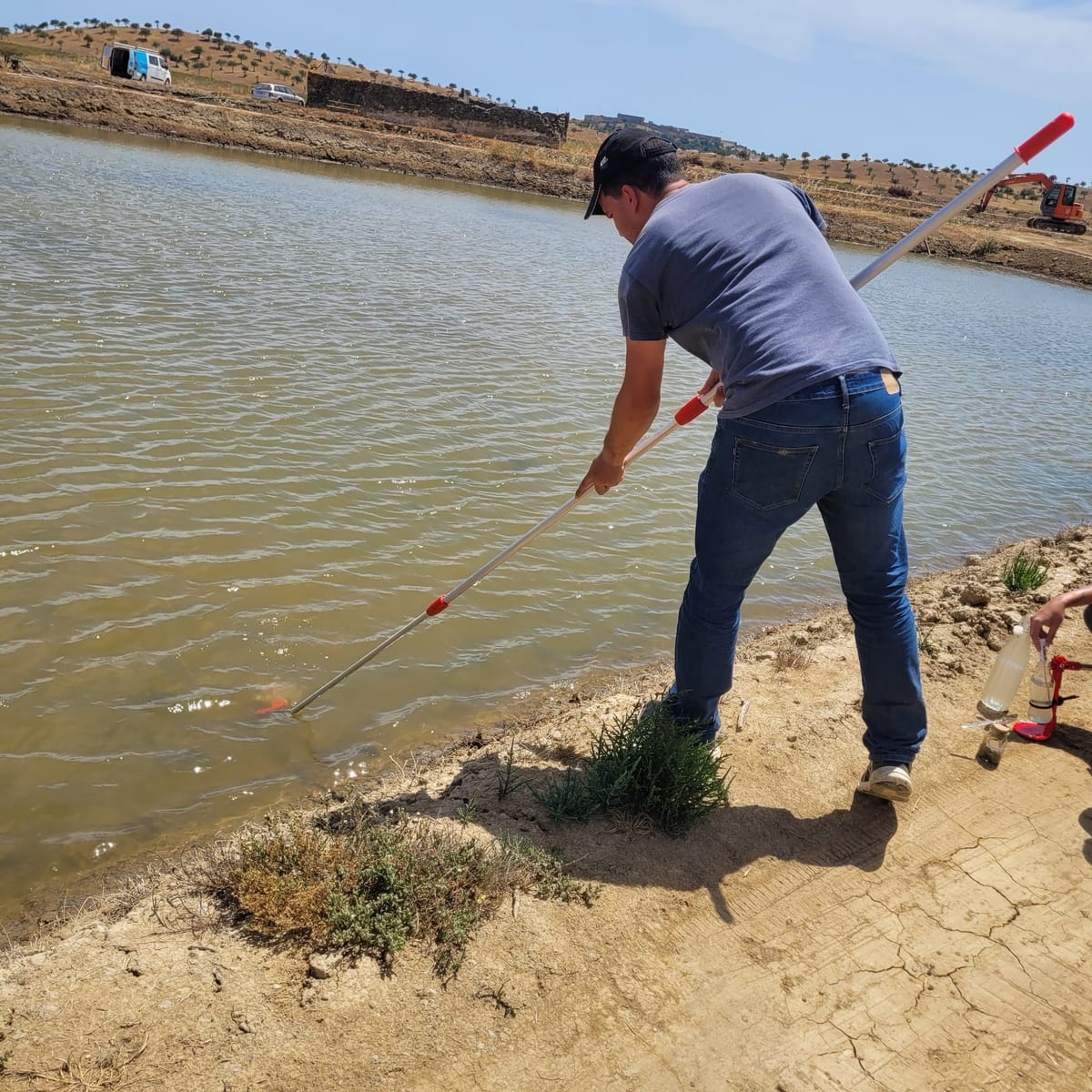 Collecting a water sample from one of the evaporation reservoirs with an extension sampler.
